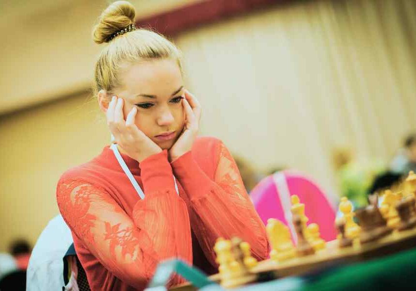 woman looking stressed about making decision at chess game