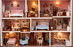 A dollhouse showcasing multiple rooms with miniature furniture, each room representing a unique household zone like a bedroom, kitchen, office, and living space.