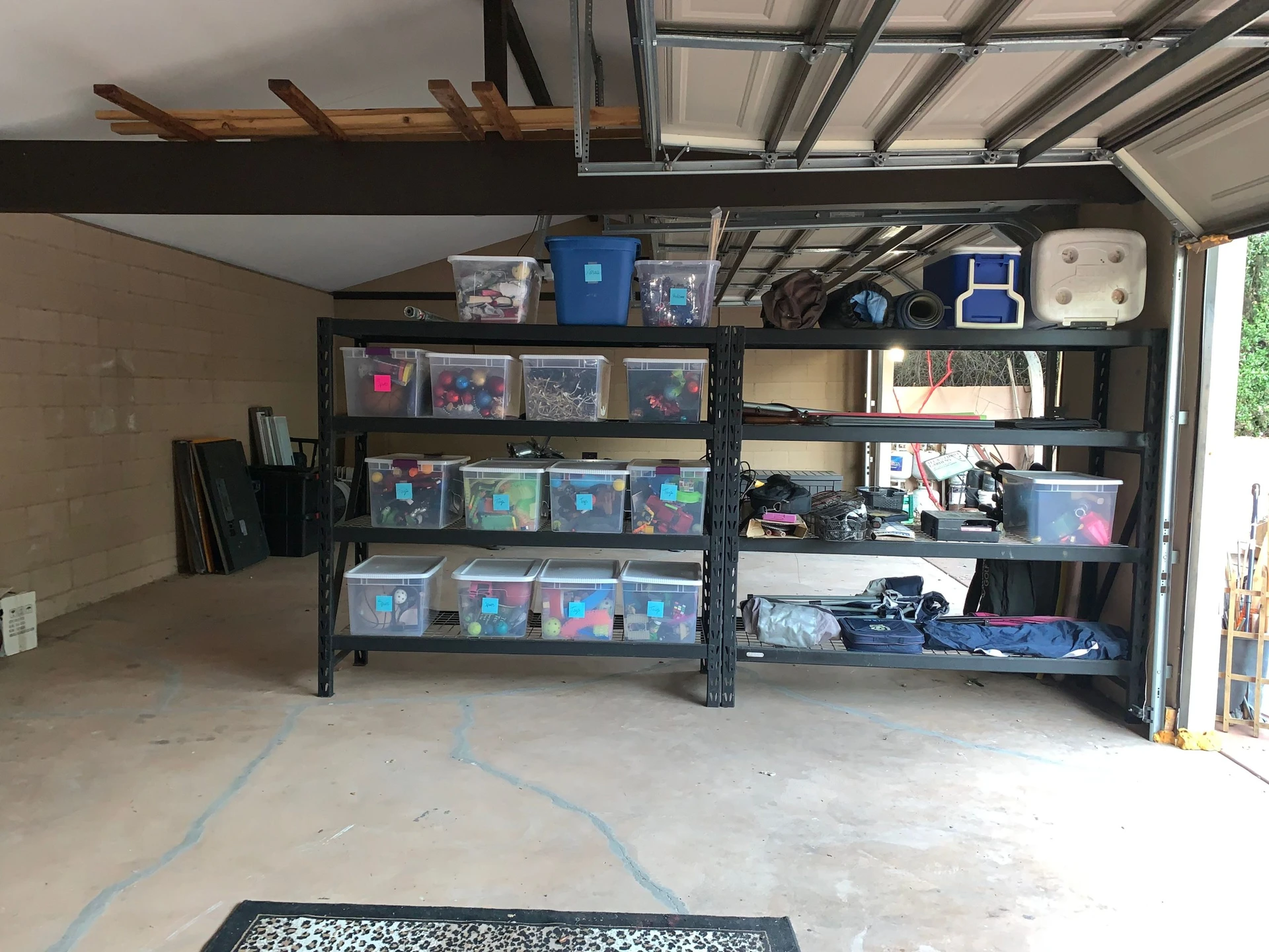A transformed and organized garage with sturdy metal shelving units, neatly labeled storage bins, and a clean, spacious floor.