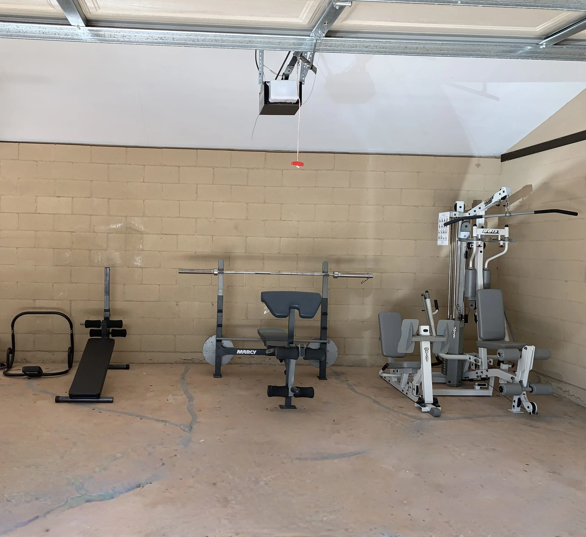 A fully transformed garage repurposed into a home gym with exercise equipment neatly arranged against a clean and spacious wall.