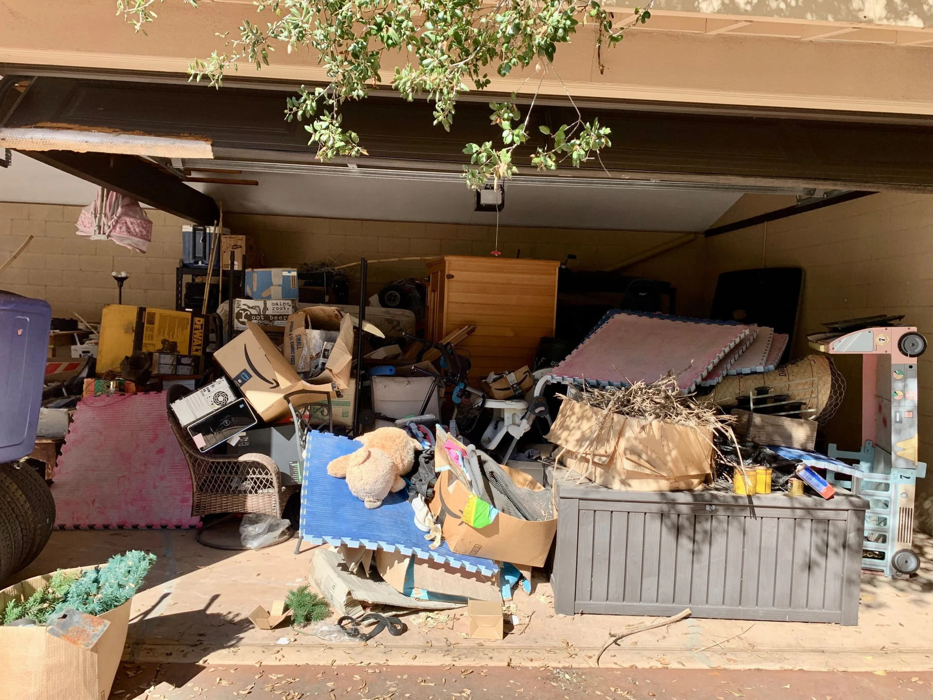 A garage filled with an overwhelming amount of clutter, including boxes, toys, old furniture, and miscellaneous items, making the space unusable.