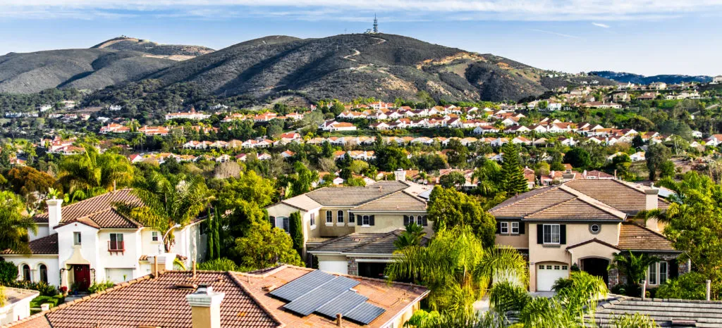A scenic view of San Marcos, CA, featuring beautiful homes nestled among lush greenery and rolling hills.