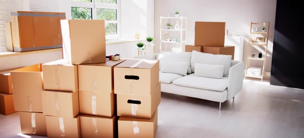 Stack of moving boxes in a bright living room ready for unpacking at home set up